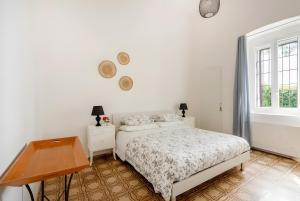 a bedroom with a bed and a desk and a window at Exclusive Maison Valentina in Monopoli