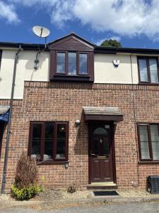 a brick house with a brown door and windows at Buckland Mews in Abingdon