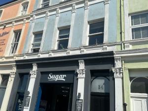 a store front of a building with a sign on it at Sugar Loft in Wigton