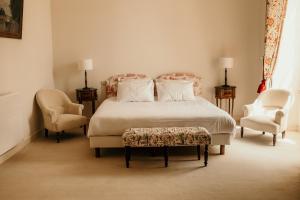 a bedroom with a bed and two chairs at Château senailhac in Tresses