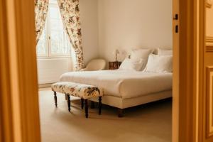 a bedroom with a bed and a chair and a window at Château senailhac in Tresses