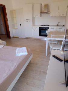 a room with a bed and a table and a kitchen at Residenza Sole in Pietra Ligure