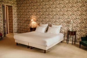 a white bed in a room with a wall at Château senailhac in Tresses
