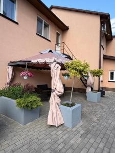 a patio with an umbrella and some plants at Euro Hotel Hostel in Kovel