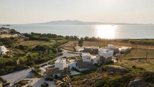 an aerial view of a house on a hill next to the water at Villa Andalusia, Steps from Orkos Beach in Naxos Chora