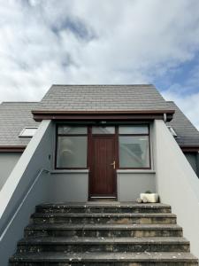 a house with stairs leading up to a door at Dough Lodge in Lahinch