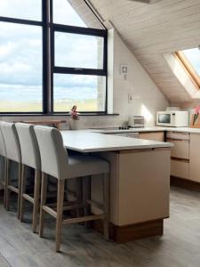 a kitchen with a large table with white chairs at Dough Lodge in Lahinch