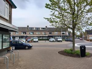 a parking lot with cars parked in front of a building at Vijverzicht Krabbendijke centrum in Krabbendijke