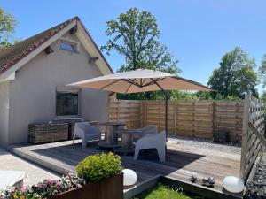 eine Terrasse mit Tisch und Sonnenschirm in der Unterkunft Eau caillou in Mettet