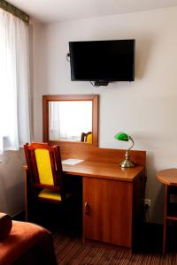 a room with a desk and a television on a wall at Szept Beskidów in Milówka