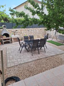 a patio with a table and chairs and a fireplace at Holiday House Snjezana in Krk