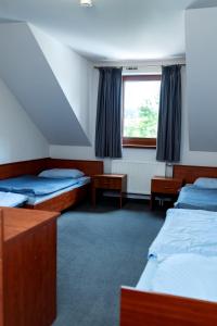 a room with two beds and a window at Szept Beskidów in Milówka