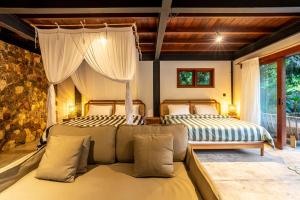 a bedroom with two beds and a couch in it at Hidden Paradise West Sumbawa Yo Yos in Sekongkang Bawa