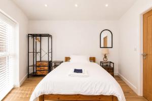 a bedroom with a bed with white sheets and a mirror at 6 En-Suites with 7 Beds Near Arena & City in Nottingham