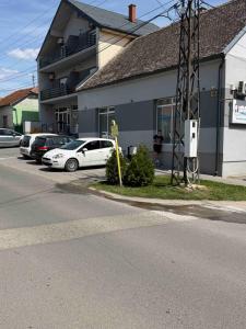 a white car parked in front of a building at IMPERIUM stan na dan in Inđija