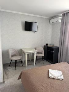 a hotel room with a table and chairs and a tv at Euro Hotel Hostel in Kovel