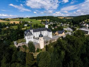 an aerial view of a large white building on a hill at Schloss Purschenstein in Neuhausen