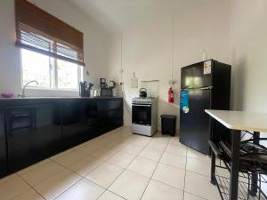 a kitchen with a black refrigerator and a sink at Secure villa in a quiet garden with pool in Albion