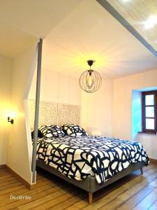 a bedroom with a bed and a chandelier at Gîte climatisé "Baugallo Accordailles" in Saint-Montan
