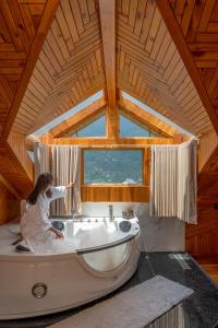 a woman sitting in a bath tub in a cabin at Padma Villa - Mountain Estate in Manali in Manāli