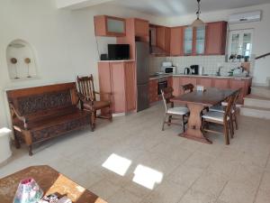 a large kitchen with a wooden table and chairs at Harmony and Horizon villas in Athani