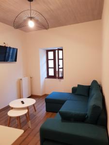 a living room with a blue couch and a table at Gîte climatisé "Baugallo Accordailles" in Saint-Montan