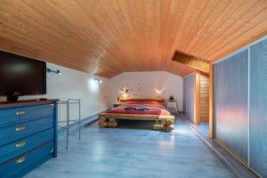 a bedroom with a bed and a wooden ceiling at Chez Corinne in Cornimont