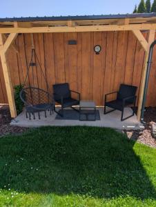 a gazebo with two chairs and a swing at Ferienhaus "Fritz" mit 3 Schlafzimmern in Seenähe in Löbnitz