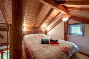 a bedroom with a bed in a room with wooden ceilings at Chalet Chez Corinne in Cornimont