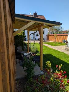 a wooden pergola with a swing in a yard at Ferienhaus "Fritz" mit 3 Schlafzimmern in Seenähe in Löbnitz