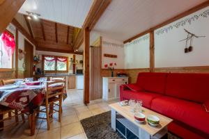 a living room with a red couch and a table at Chalet Chez Corinne in Cornimont
