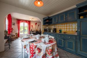 a kitchen with blue cabinets and a table in a room at Chez Corinne in Cornimont