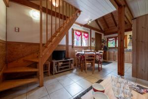 a kitchen and dining room with a staircase in a house at Chalet Chez Corinne in Cornimont