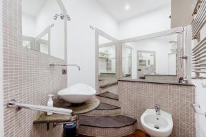 a bathroom with a sink and a toilet and mirrors at Toledo Apartment until 7 people 2 bathrooms in Naples