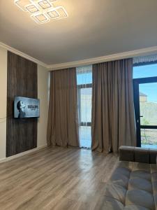 a living room with a couch and a television at M&M Hotel in Pʼarakʼar