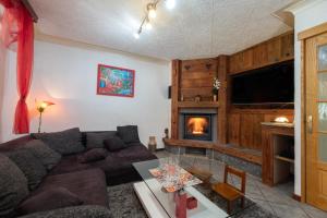 a living room with a couch and a fireplace at Chez Corinne in Cornimont