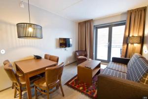 a living room with a table and a dining room at Skistar Lodge Trysil in Trysil