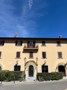 a large yellow building with a balcony on top of it at Hotel Sangallo in Monte San Savino