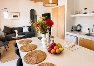 a kitchen with a table with a bowl of fruit on it at Garden Residence Andros with Sea View & Pool in Gavrio