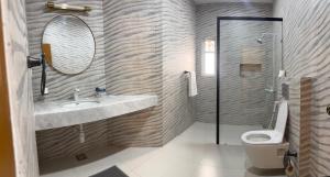 a bathroom with a sink and a toilet and a mirror at Sable d'Or Résidence by Star 'A' in Karachi +15 photos