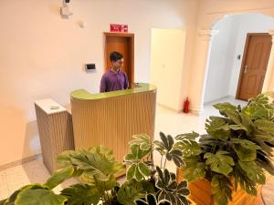 a man standing at a podium in a room with plants at Sable d'Or Résidence by Star 'A' in Karachi