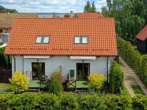 a small white house with an orange roof at Mazurska Apartamenty in Rydzewo