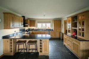 a kitchen with a large island with two bar stools at Nistagar, Harray, Orkney - OR00604F in Harray