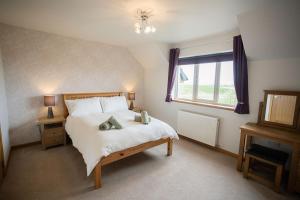 a bedroom with a large bed and a window at Nistagar, Harray, Orkney - OR00604F in Harray