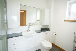 a white bathroom with a sink and a toilet at Nistagar, Harray, Orkney - OR00604F in Harray +21 photos