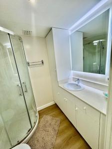 a bathroom with a sink and a shower and a mirror at Mediterráneo Suites Port in Jávea +4 photos