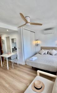 a bedroom with a bed and a ceiling fan at Mediterráneo Suites Port in Jávea