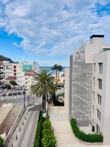 a city street with a building and a palm tree at Mediterráneo Suites Port in Jávea