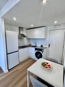 a kitchen with white cabinets and a table with a plate on it at Mediterráneo Suites Port in Jávea