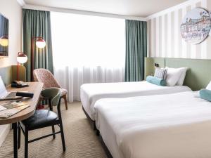a hotel room with two beds and a desk at Mercure Northampton in Northampton +110 photos